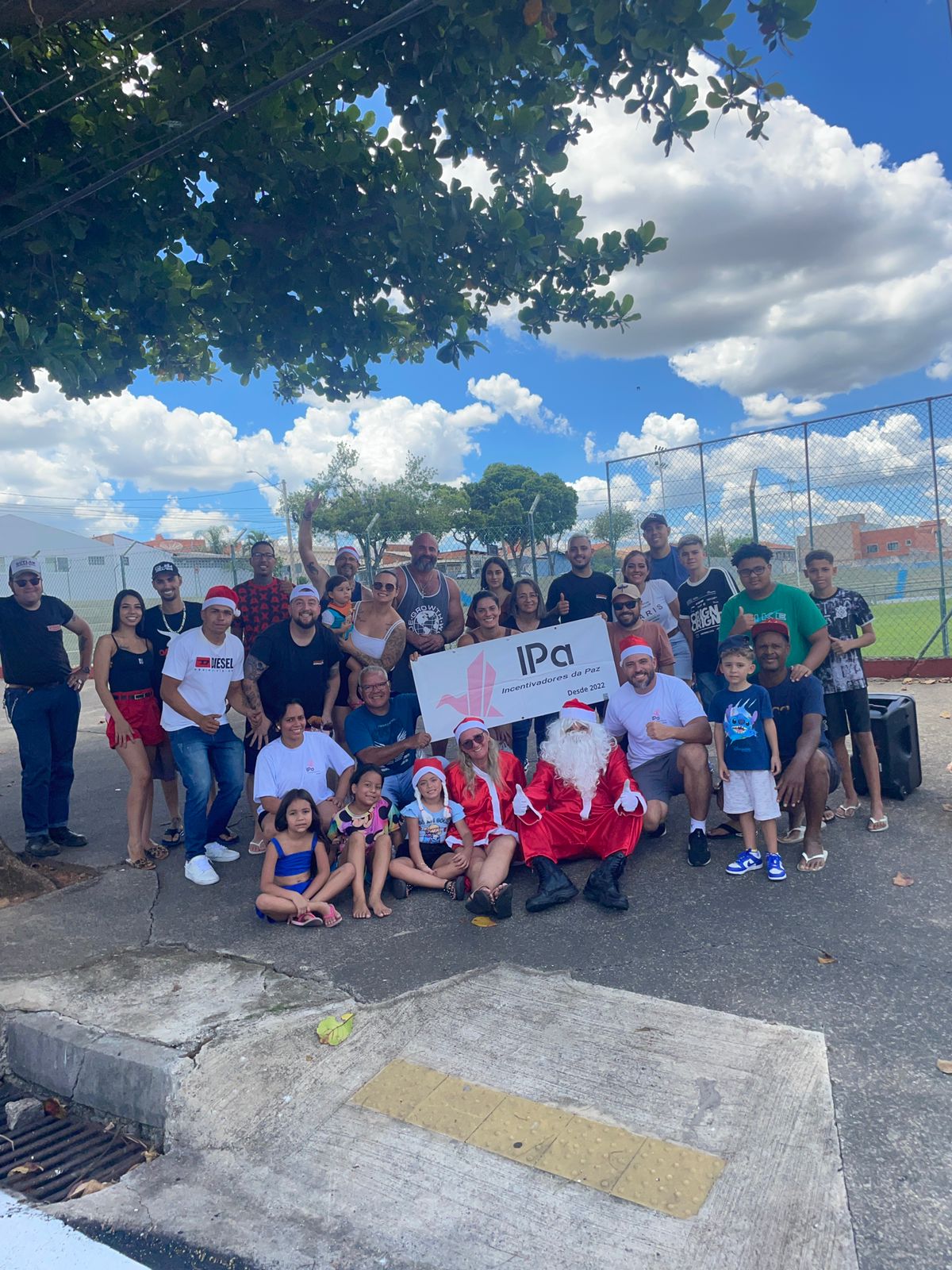 Natal solidário da IPa — crianças com Papai Noel e banner IPa